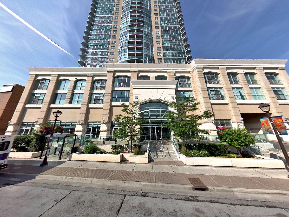 Modern residential tower overlooks a stylish, glass-fronted building surrounded by greenery. The image highlights urban architecture and city life.