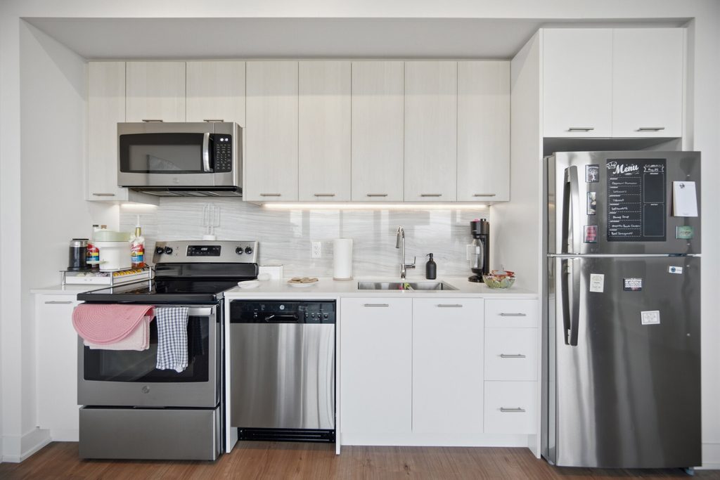 Modern kitchen featuring stainless steel appliances, white cabinetry, and a sleek design. Ideal for showcasing contemporary interior styles.